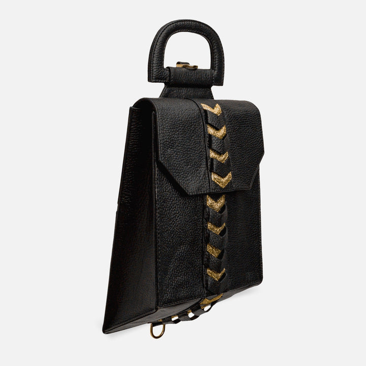 Black textured leather handbag with a top handle and gold chevron detailing down the front