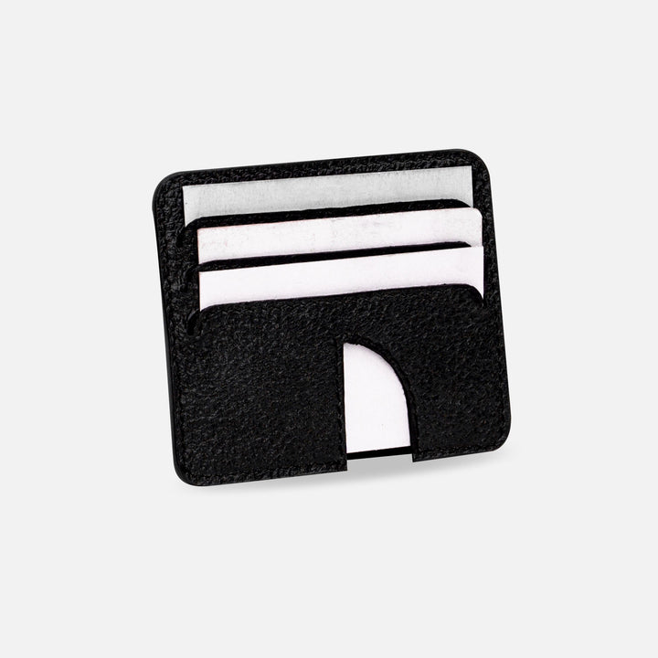 Black leather minimalist card holder with white cards on white background