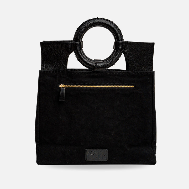 Black canvas tote bag with round leather wrapped handles and front zipper pocket
