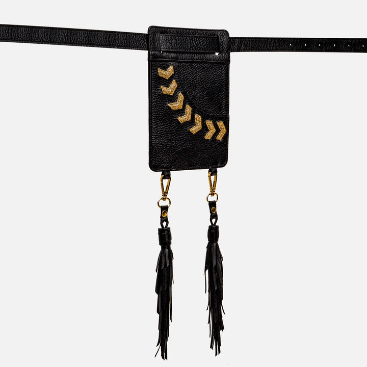 Black leather belt bag with gold chevron embroidery and dual black tassels on white background