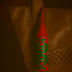 Handcrafted red and green leather tassel keychain hanging on a woven brown leather bag