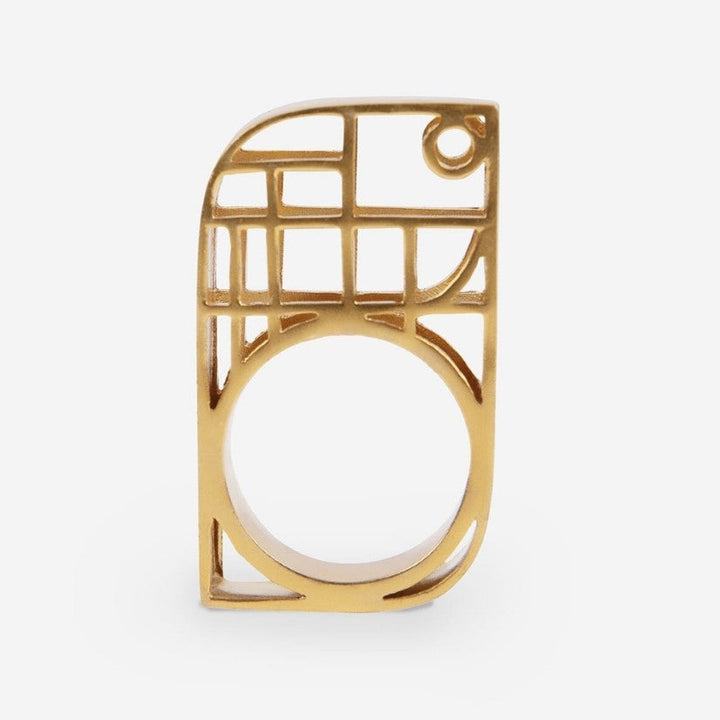 Modern gold metal ring with geometric openwork design on white background