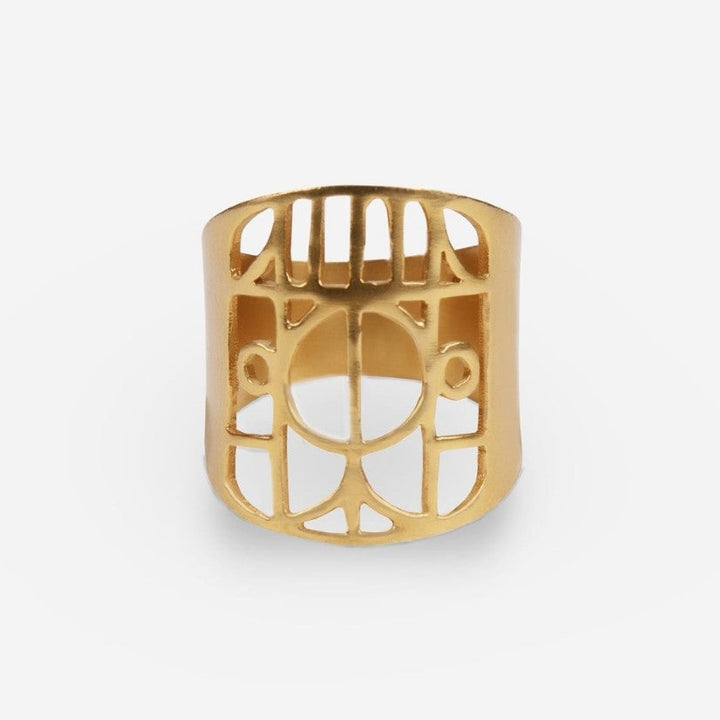 Gold metal ring with geometric cut-out pattern on white background