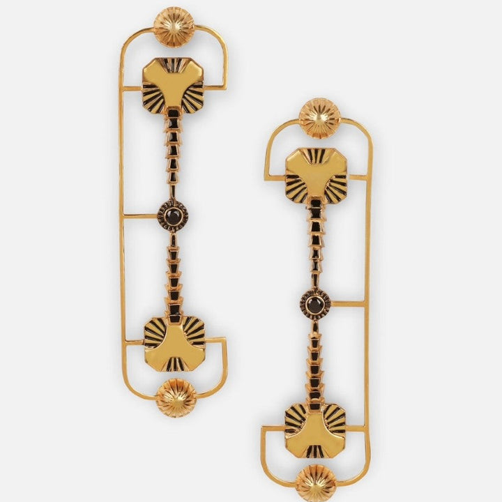 Handcrafted gold-tone metal earrings with geometric black enamel accents on white background