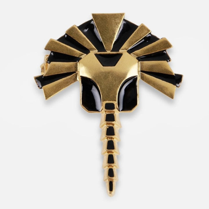 Gold and black enamel metal brooch shaped like a stylized scorpion with geometric patterns