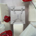 Minimalist beige leather backpack with decorative straps, surrounded by red anthurium flowers and foam blocks