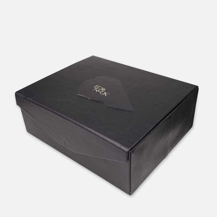 Black textured rectangular gift box with embossed gold logo on lid, white background