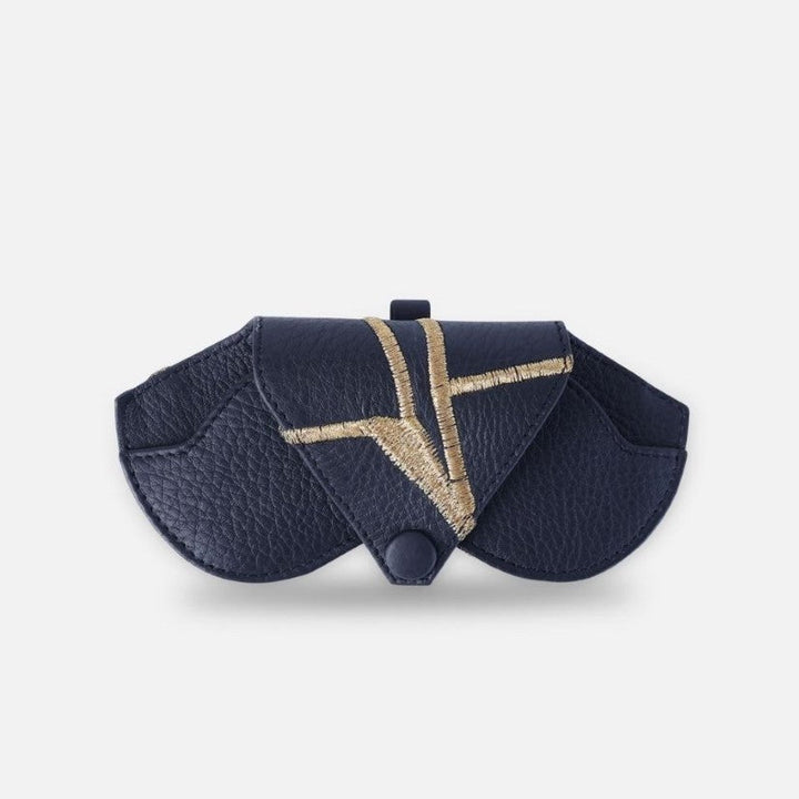 Designer Black leather sunglass case with gold embroidered geometric design and snap closure on white background