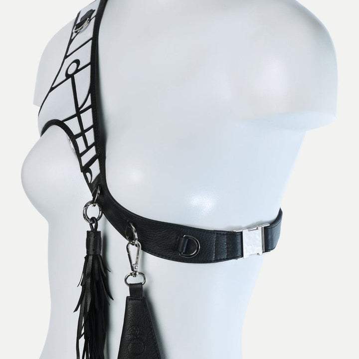 Black leather upcycled applique harness with tassel and attachments on white mannequin torso