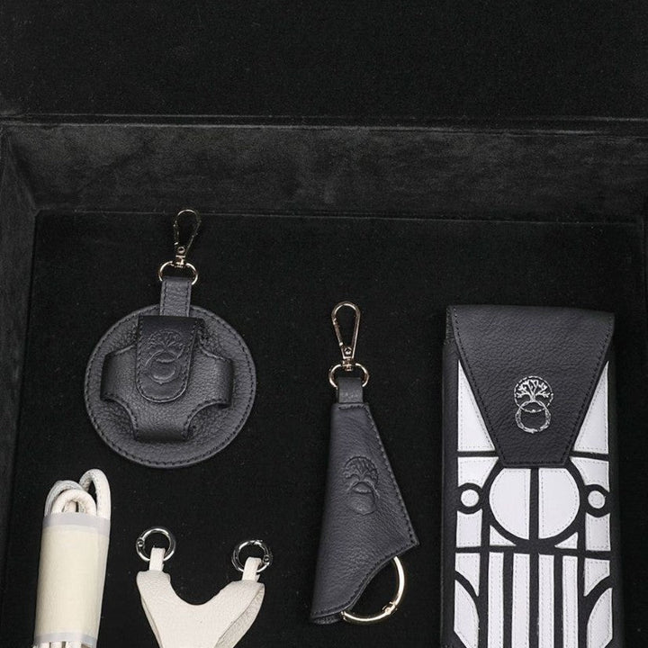 Black and white leather accessories set in black velvet box with tree emblem details