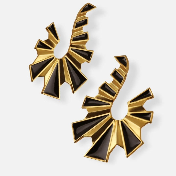 Pair of gold and black enamel geometric earrings with sunburst design on white background