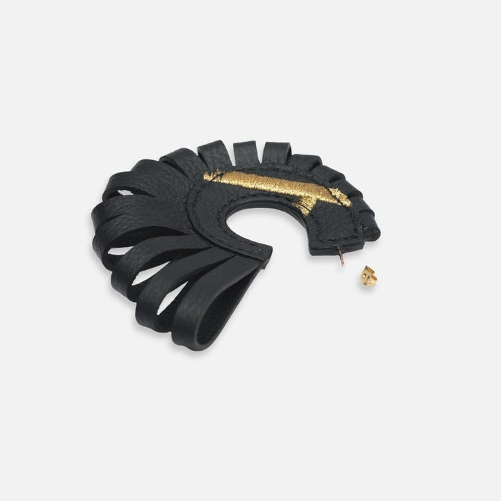 Black leather hoop earring with gold accent and cut-out fringe design on white background