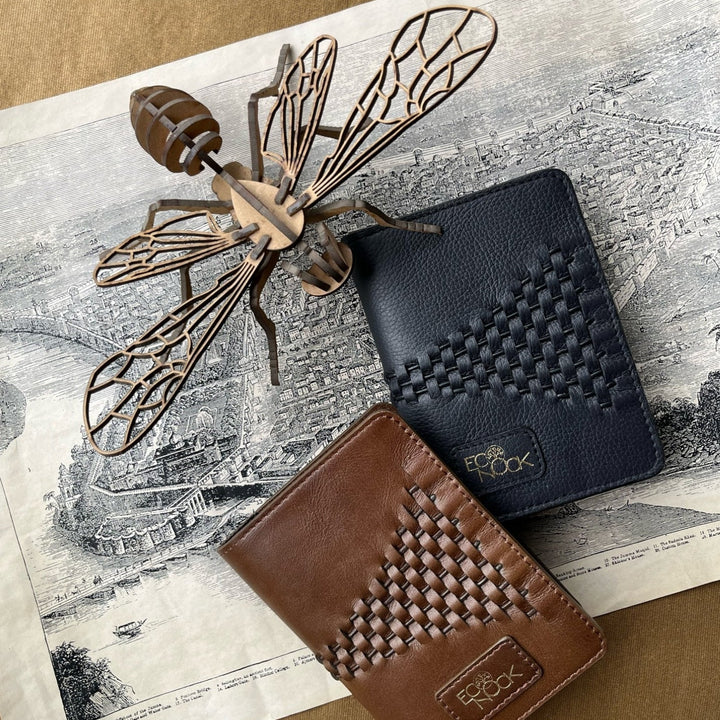Brown and black leather upcycled passport covers with woven design on vintage map and wooden bee sculpture