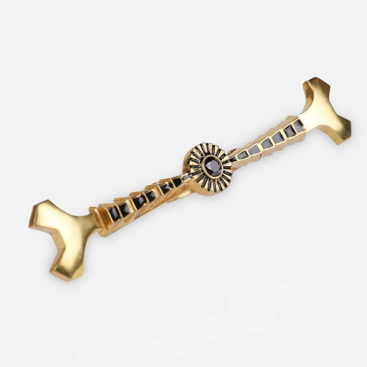 gold and black enamel metal ring with geometric design on white background