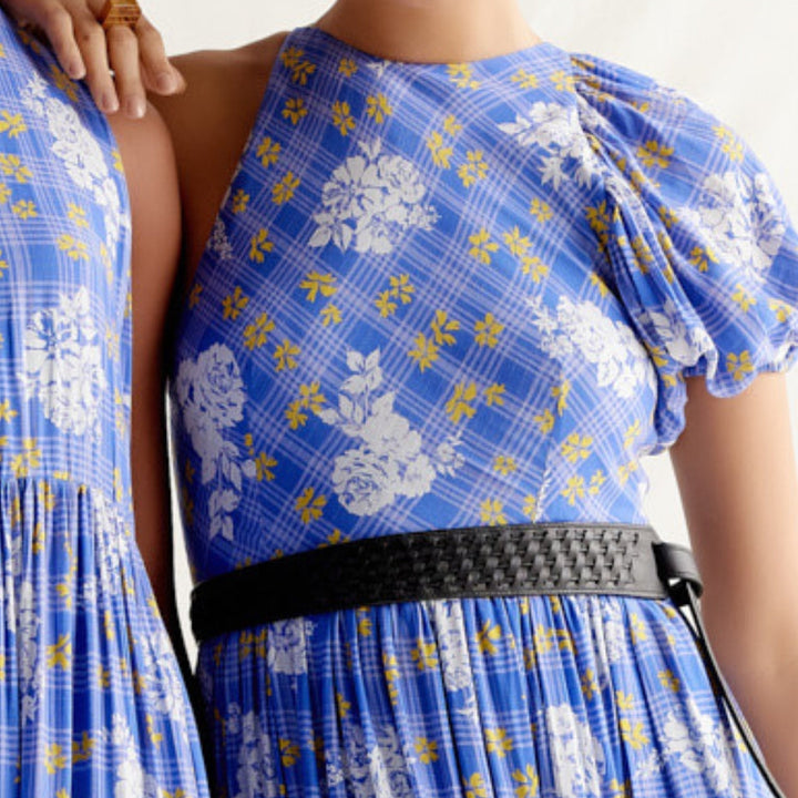 Close-up of blue floral plaid dress with puff sleeve and black woven belt on model