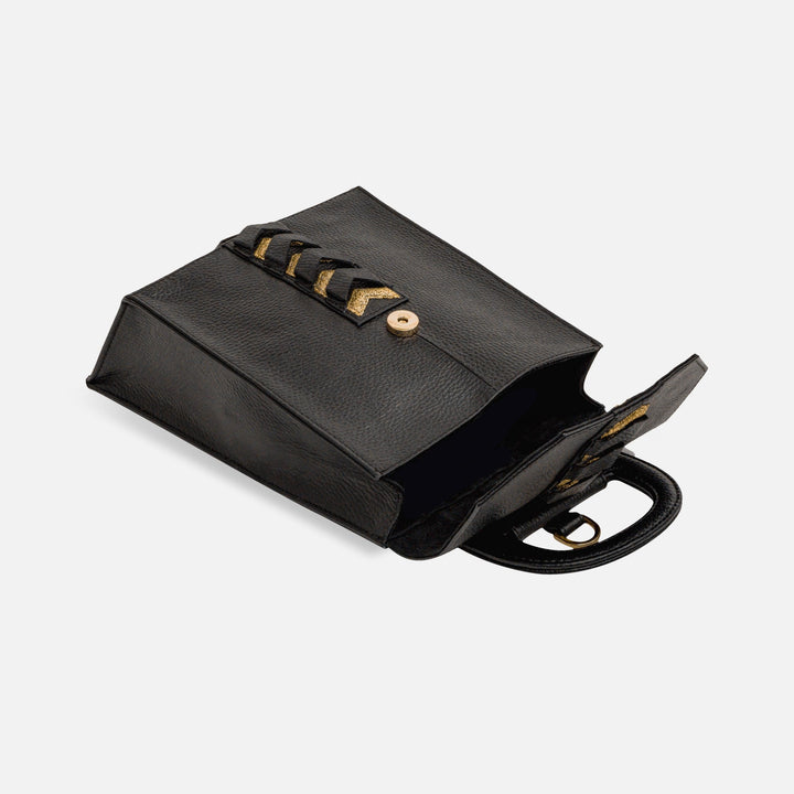 Black leather handbag with gold button closure and decorative gold chevron accents