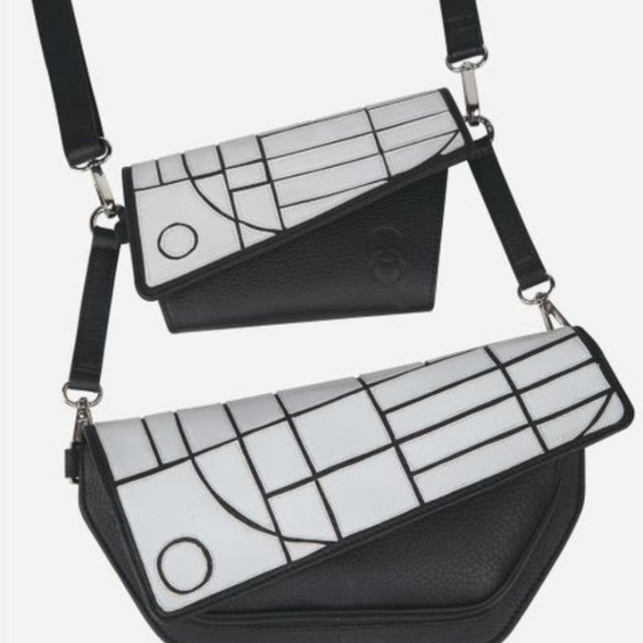 Two black leather crossbody bags with white geometric pattern flaps and adjustable straps