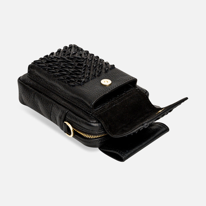 Black leather crossbody bag with woven flap, gold magnetic snap, and zipper pocket