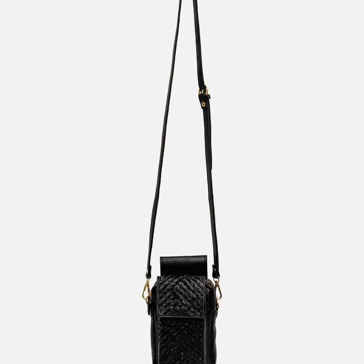 Black textured leather crossbody bag with adjustable strap and gold hardware on white background