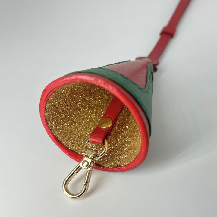 Red and green leather keychain holder with gold glitter interior and gold clasp on white background